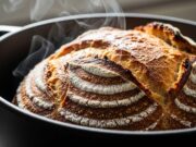 Pane fatto in casa 2026: guida alla lievitazione naturale e trucco per la crosta croccante Pane fatto in casa cotto in pentola di ghisa con crosta croccante e vapore che sale