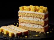 Torta Mimosa per la Festa della Donna: il trucco per una crema che non collassa Fetta tagliata di torta mimosa con strati netti di pan di spagna e crema diplomatica densa.