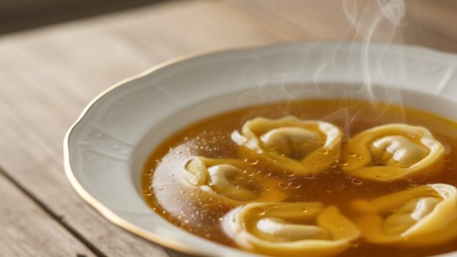 Brodo di Natale chiarificato ambrato, perfetto per tortellini in atmosfera festiva.