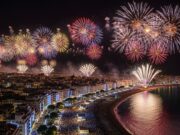 Le 5 mete imperdibili per festeggiare il Capodanno 2026 Vista spettacolare dei fuochi d'artificio di Capodanno 2026 su una città costiera affollata.