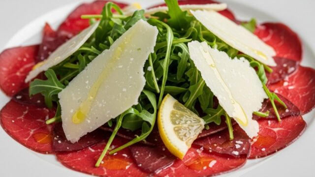Fette sottili di carpaccio di bresaola condite con scaglie di parmigiano, rucola e dressing, antipasto gourmet elegante.