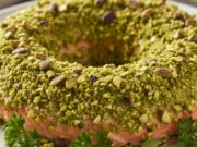 Ghirlanda di salmone in crosta e pistacchio: il secondo scenografico pronto in 20 minuti Ghirlanda di salmone in crosta di pistacchio, con contorno verde, presentato come secondo piatto elegante.