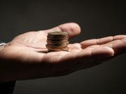 Loud Budgeting: quando dire ‘non ho soldi’ batte il quiet luxury Monete tenute fieramente in primo piano, simbolo del Loud Budgeting contro l'ostentazione.