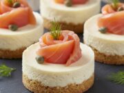 Mini cheesecake salate al salmone e taralli: l’antipasto senza cottura facile e chic Mini cheesecake salate al salmone affumicato e taralli croccanti, antipasto monoporzione elegante su piatto da portata.