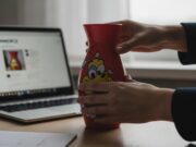 I regali di Natale indesiderati: come riciclarli o rivenderli online Mani che preparano un regalo indesiderato per la vendita online.