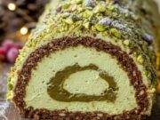 Tronchetto di Natale furbo al pistacchio: la ricetta senza cottura pronta in 20 minuti Tronchetto di Natale al pistacchio senza cottura, fetta in primo piano, con ripieno cremoso e granella verde.