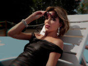 Red Carpet – Vip al Tappeto 2: Alba Parietti e la sfida bodyguard su Prime Video Alba Parietti in abito nero e occhiali da sole su una sdraio per la seconda stagione di Red Carpet - Vip al tappeto