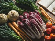 Mangiare sano e spendere la metà: la guida alla spesa di gennaio Una giovane donna che organizza provviste invernali sane in una cucina moderna, mettendo in mostra una spesa intelligente.