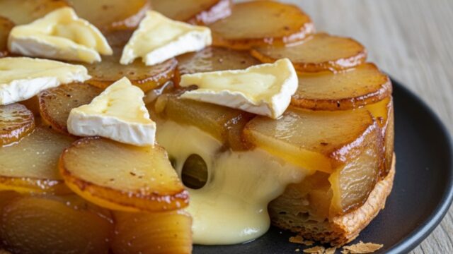 Torta salata rovesciata di patate sottili e brie fuso, con pasta sfoglia dorata, servita su piatto rustico.