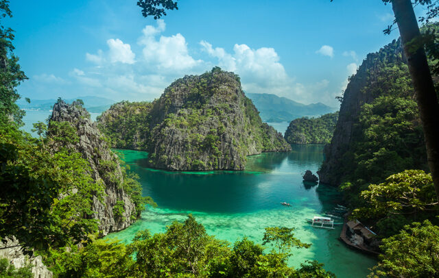 Veduta panoramica dall'alto delle lagune di El Nido a Palawan, Filippine, con barche tipiche e rocce carsiche.