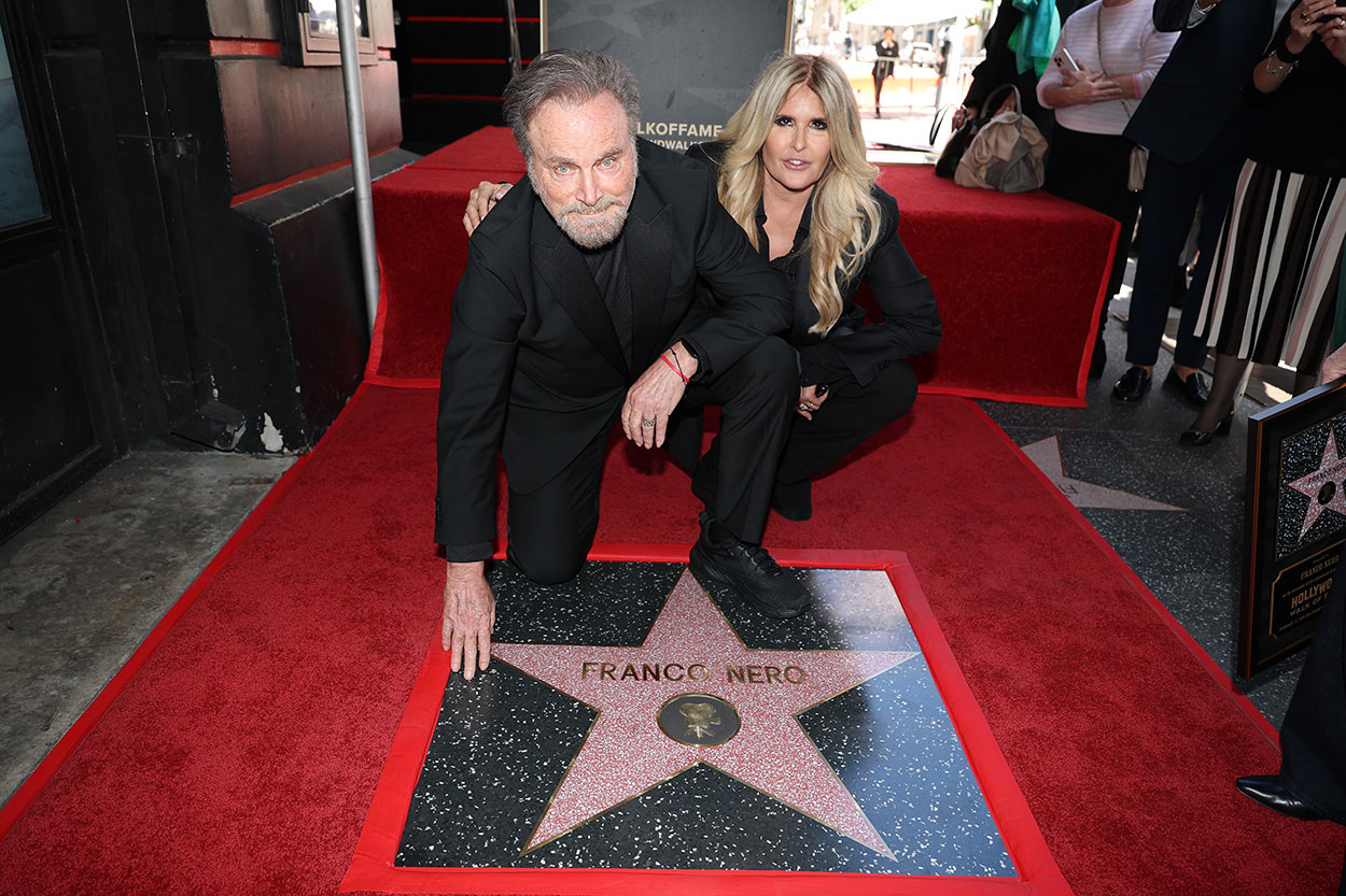 Franco Nero posa in ginocchio toccando la sua stella sulla Hollywood Walk of Fame, accanto a Tiziana Rocca