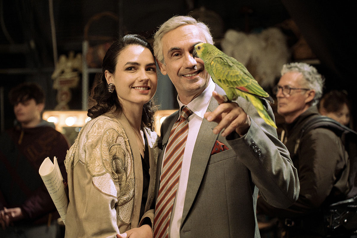 Fabrizio Gifuni nel ruolo di Enzo Tortora e Romana Maggiora Vergano posano sorridenti con il pappagallo verde in una scena della serie TV Portobello.