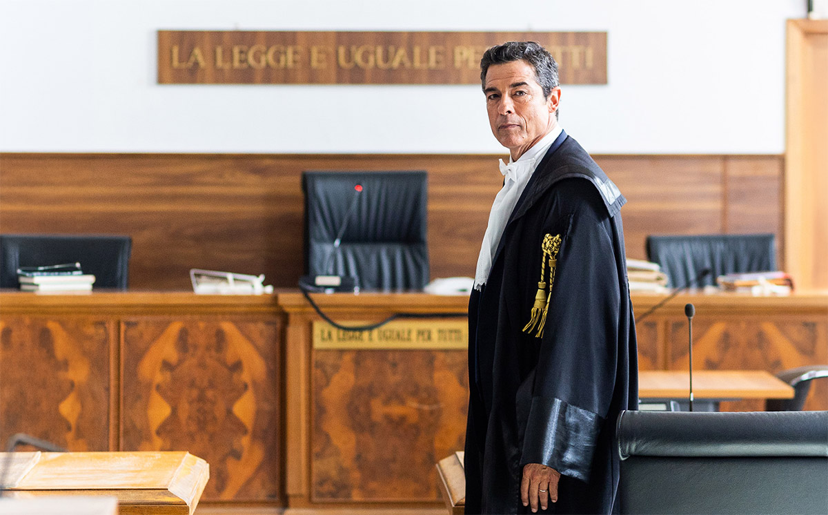 Alessandro Gassmann interpreta l'avvocato Guido Guerrieri al telefono in una scena notturna per le strade di Bari nella serie TV Rai 1