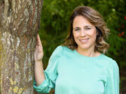 Il significato di Sanremo Vibes: quando il Festival diventa un laboratorio culturale Ritratto all'aperto dell'attrice e conduttrice Annamaria Fittipaldi: sorridente e in posa rilassata con una mano appoggiata al tronco di un albero, indossa una blusa verde acqua su uno sfondo naturale sfocato