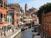 Venezia oltre i canali: luoghi segreti e chic da esplorare Ecco il tag alt perfetto per l'immagine: ottimizzato, descrittivo e della lunghezza ideale per l'accessibilità e la SEO. Tag Alt: "Veduta di un canale tranquillo a Venezia con persone che camminano lungo la fondamenta, edifici storici colorati e un campanile sullo sfondo.