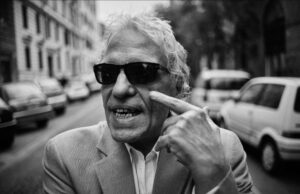 Grandi ospiti al BAFF 2026: da Abel Ferrara a Donato Carrisi per l’apertura Abel Ferrara in un ritratto in bianco e nero con occhiali da sole e giacca, ospite d'onore all'apertura del BAFF 2026