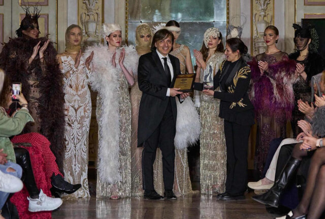 Anton Giulio Grande riceve il premio Best Womenswear Designer circondato dalle modelle della collezione Oriente a Villa Borromeo.