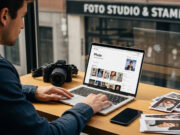 Stampare le foto online o in negozio: quale conviene e come farlo Un uomo utilizza un laptop per ordinare stampe fotografiche online, con foto cartacee e una fotocamera sul tavolo, davanti a un negozio di fotografia tradizionale.