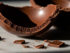 Uovo di Pasqua: la guida per una cristallizzazione stabile Macro di un uovo di Pasqua in cioccolato fondente spezzato su marmo, con bordi netti e superficie lucida