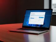 Falso aggiornamento Windows 11 25H2: il dettaglio visivo che smaschera il malware Laptop su una scrivania in legno che mostra un finto aggiornamento Windows 11 con dettagli grafici sospetti.