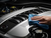 Lavare il motore dell’auto: l’errore con la lancia che distrugge la centralina Dettaglio del vano motore di una vettura moderna durante le operazioni di pulizia a secco con panno in microfibra