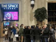 L’omaggio romano a Sanjay Leela Bhansali: il trionfo dell’estetica indiana Folla di spettatori in attesa davanti all'ingresso del The Space Cinema a Roma, sotto il maxischermo luminoso che proietta la locandina del film storico Bajirao Mastani.