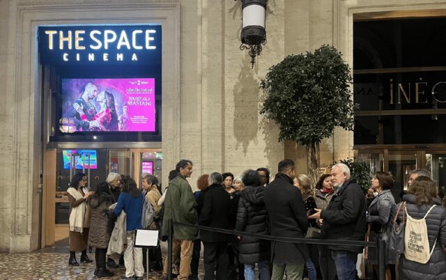 Folla di spettatori in attesa davanti all'ingresso del The Space Cinema a Roma, sotto il maxischermo luminoso che proietta la locandina del film storico Bajirao Mastani.