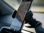 Lo smartphone come navigatore in auto: l’errore al sole che spacca lo schermo Smartphone montato su supporto a ventosa sul cruscotto di un'auto, con l'applicazione di navigazione mappe attiva sullo schermo.