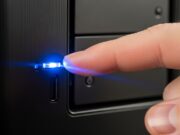 Aggiornamento Windows 11 25H2 forzato: come proteggere i dati Un dito indica la luce lampeggiante del disco fisso su un computer nero