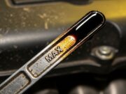 Olio motore: il momento sbagliato in cui lo controlla il 90% degli automobilisti Astina di controllo del livello dell'olio motore estratta che mostra un livello di lubrificante oltre la soglia massima consentita.