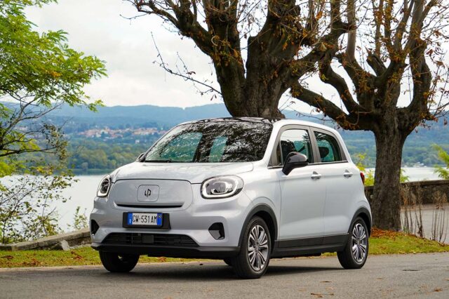 Leapmotor T03 citycar elettrica con targa italiana parcheggiata vicino a un lago