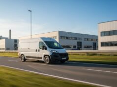 La rivoluzione della mobilità commerciale leggera nelle province produttive Furgone commerciale bianco a noleggio in movimento su strada in un distretto industriale in Brianza per la logistica aziendale.
