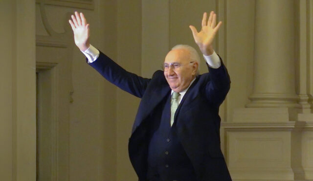 Pippo Baudo sul palco con le braccia alzate