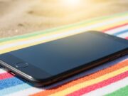 Smartphone nella borsa da spiaggia: la temperatura che gonfia la batteria in pochi minuti Smartphone sul telo da spiaggia esposto al sole diretto estivo