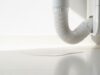 Il condizionatore perde acqua: non chiamare il tecnico prima di controllare questo Tubo di scarico della condensa di un condizionatore split con pozzanghera d'acqua sul pavimento