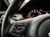 Il cruise control in salita aumenta i consumi: lo studio che cambia le abitudini in autostrada Pulsante Adaptive Cruise sul volante di un'auto moderna con quadro strumenti sfocato sullo sfondo
