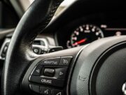 Il cruise control in salita aumenta i consumi: lo studio che cambia le abitudini in autostrada Pulsante Adaptive Cruise sul volante di un'auto moderna con quadro strumenti sfocato sullo sfondo