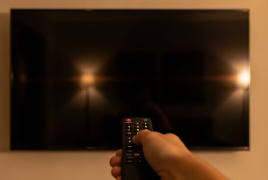 Mondiali su DAZN: lo schermo della smart TV si spegne da solo, ecco perché Telecomando puntato verso uno schermo di smart TV completamente nero e spento in un salotto, durante la visione di una partita dei Mondiali 2026 su DAZN