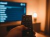 I canali del digitale terrestre sono cambiati a giugno: cosa fare adesso sul telecomando Telecomando moderno puntato verso uno schermo TV con lista canali del digitale terrestre
