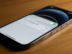 Apple Intelligence sul tuo iPhone: cosa attivare adesso che sta per cambiare tutto iPhone moderno su scrivania in legno con schermata Impostazioni che mostra la voce Apple Intelligence e Siri con toggle verde attivo