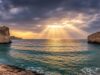 Odissea di Nolan al cinema il 16 luglio: perché è il film dell’estate che aspettavi da anni Mare mediterraneo con scogliere rocciose e cielo drammatico al tramonto, atmosfera epica ispirata all'Odissea di Omero