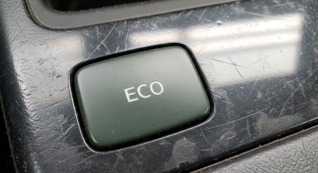 Modalità ECO auto: il tasto sul cruscotto Tasto ECO verde su cruscotto di un'auto moderna