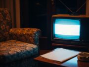 Drive In, il programma degli anni ’80 che cambiò la domenica sera italiana per sempre Televisore CRT anni '80 acceso in un salotto italiano buio con poltrona a fiori e posacenere sul tavolino