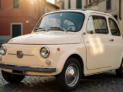 Fiat 500: il caso più unico nella storia dell’automobile riguarda chi la comprò per primo Fiat Nuova 500 del 1957 color avorio parcheggiata su una strada in ciottoli di un borgo italiano al tramonto