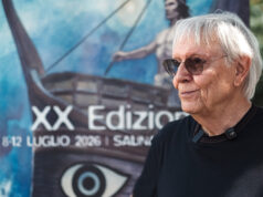 Milo Manara disegna la sua Odissea al SalinaDocFest, mentre il cinema aspetta quella di Nolan Milo Manara al SalinaDocFest 2026 davanti al poster dell'Odissea, XX edizione del festival a Salina