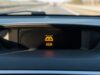 Frenata fantasma in autostrada: perché l’auto frena da sola e cosa fare se capita Spia luminosa del sistema di frenata automatica di emergenza sul cruscotto di un'automobile.