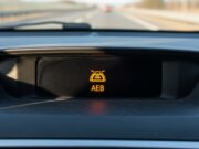 Frenata fantasma in autostrada: perché l’auto frena da sola e cosa fare se capita Spia luminosa del sistema di frenata automatica di emergenza sul cruscotto di un'automobile.