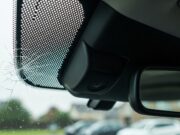 Grandine sull’auto: il controllo che il carrozziere spesso non fa Telecamera ADAS dietro lo specchietto retrovisore con microfrattura da grandine sul parabrezza