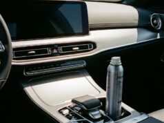 Deodorante spray in auto d’estate: il punto esatto in cui la bomboletta può esplodere Bomboletta spray metallica appoggiata nel vano portaoggetti dell'auto, esposta al calore dell'abitacolo