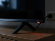 La smart TV in stand-by continua a consumare corrente: quanto costa lasciarla così ogni sera Dettaglio del led rosso acceso su una smart tv spenta in salotto.